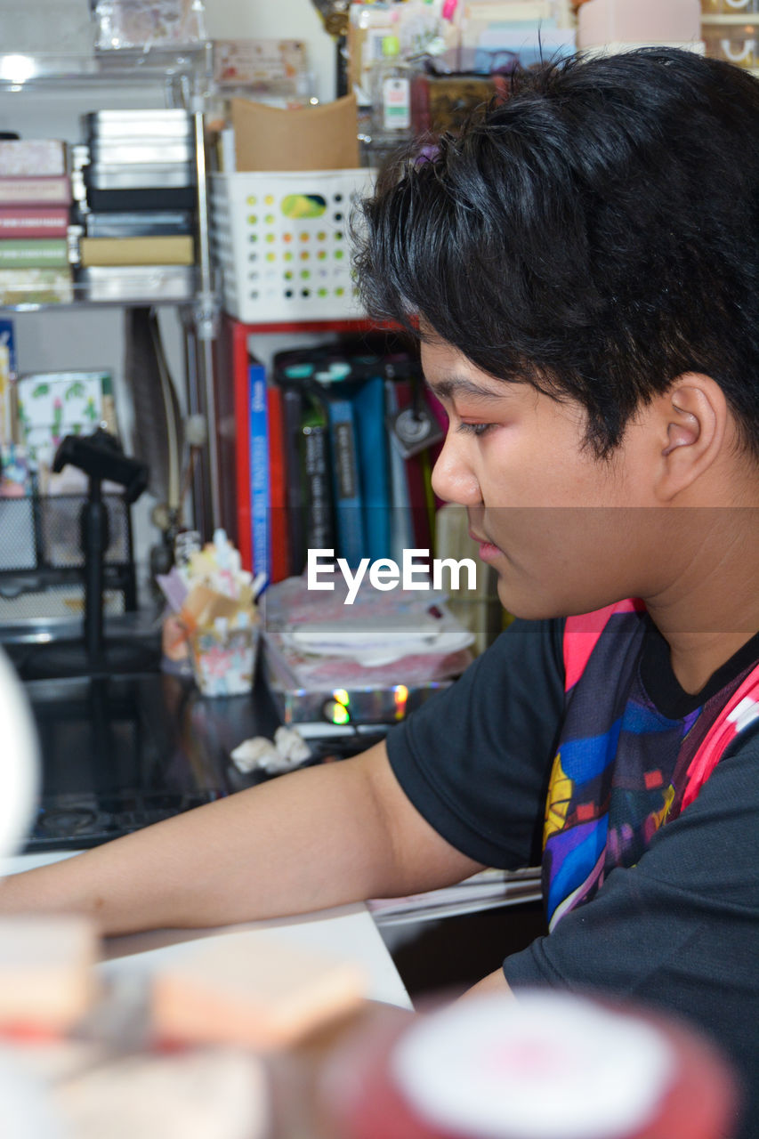 Portrait of a teenage girl sitting in front of a computer, typing