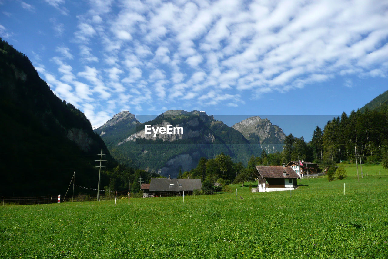 Scenic view of field and mountains against sky