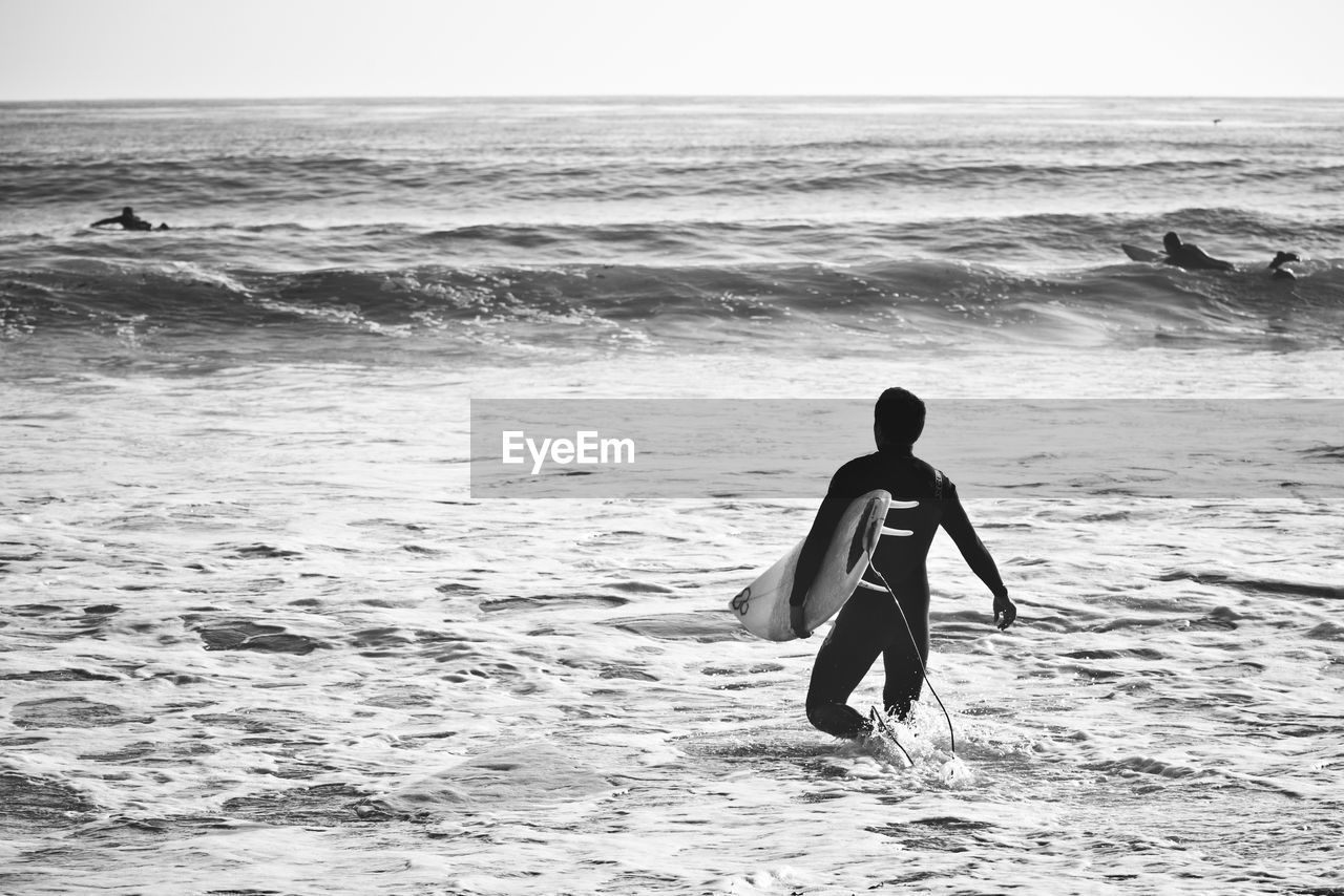 FULL LENGTH OF MAN ON BEACH AGAINST SEA