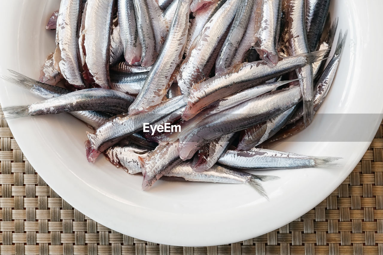 Overhead view of raw fish in plate on table