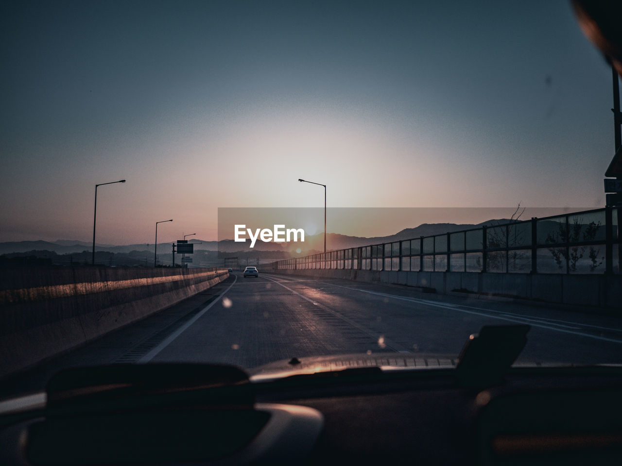 ROAD SEEN THROUGH CAR WINDSHIELD