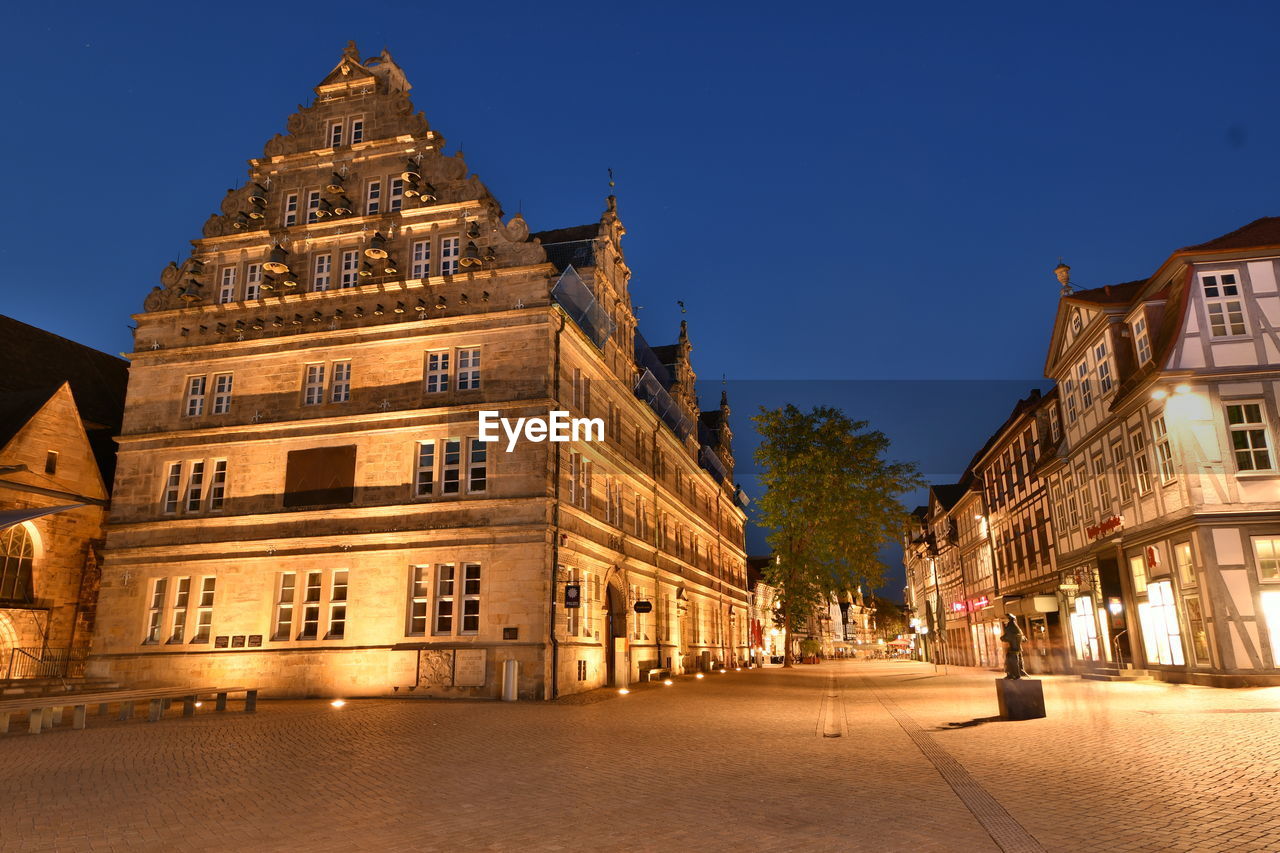 Street amidst buildings against clear sky at night