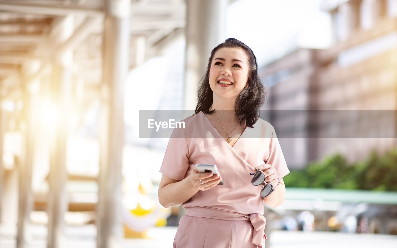 Portrait of a smiling young woman in city