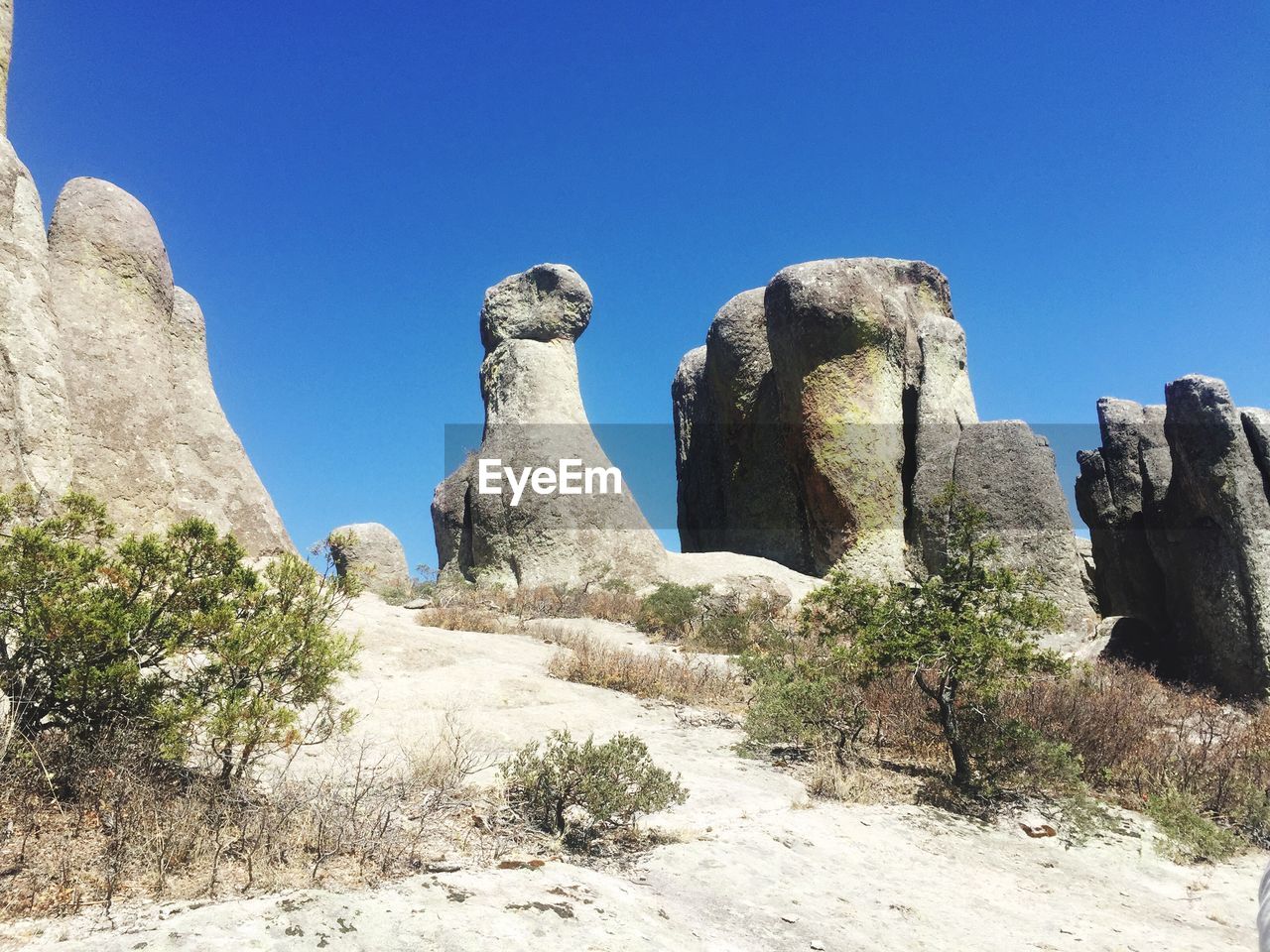 Low angle view of rock formation against clear blue sky