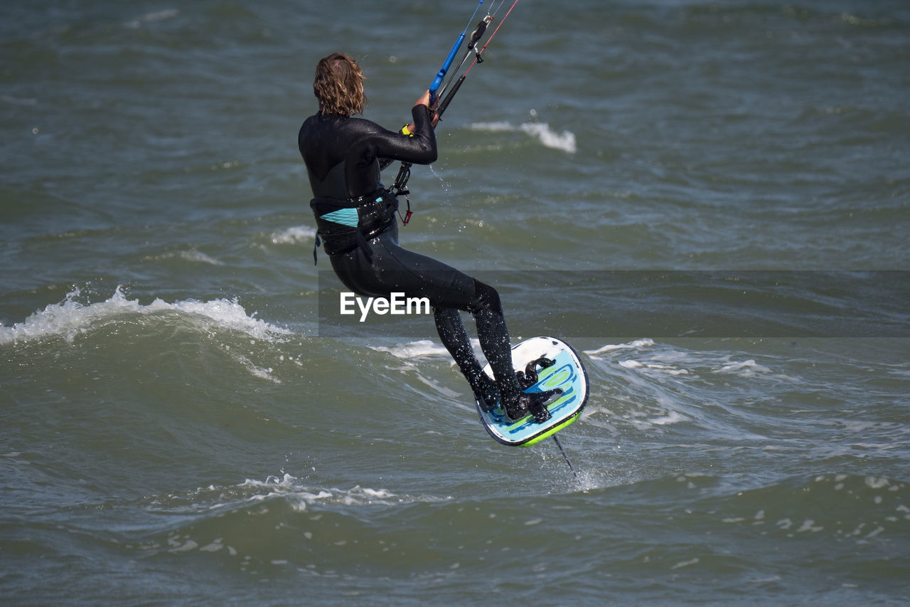 rear view of man surfing in lake