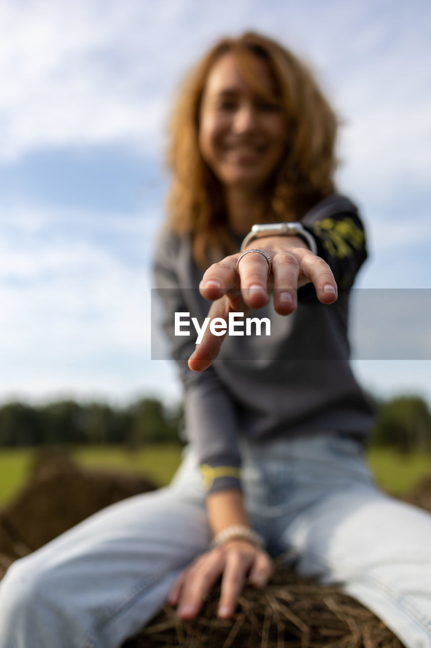 Portrait of a smiling young woman against sky