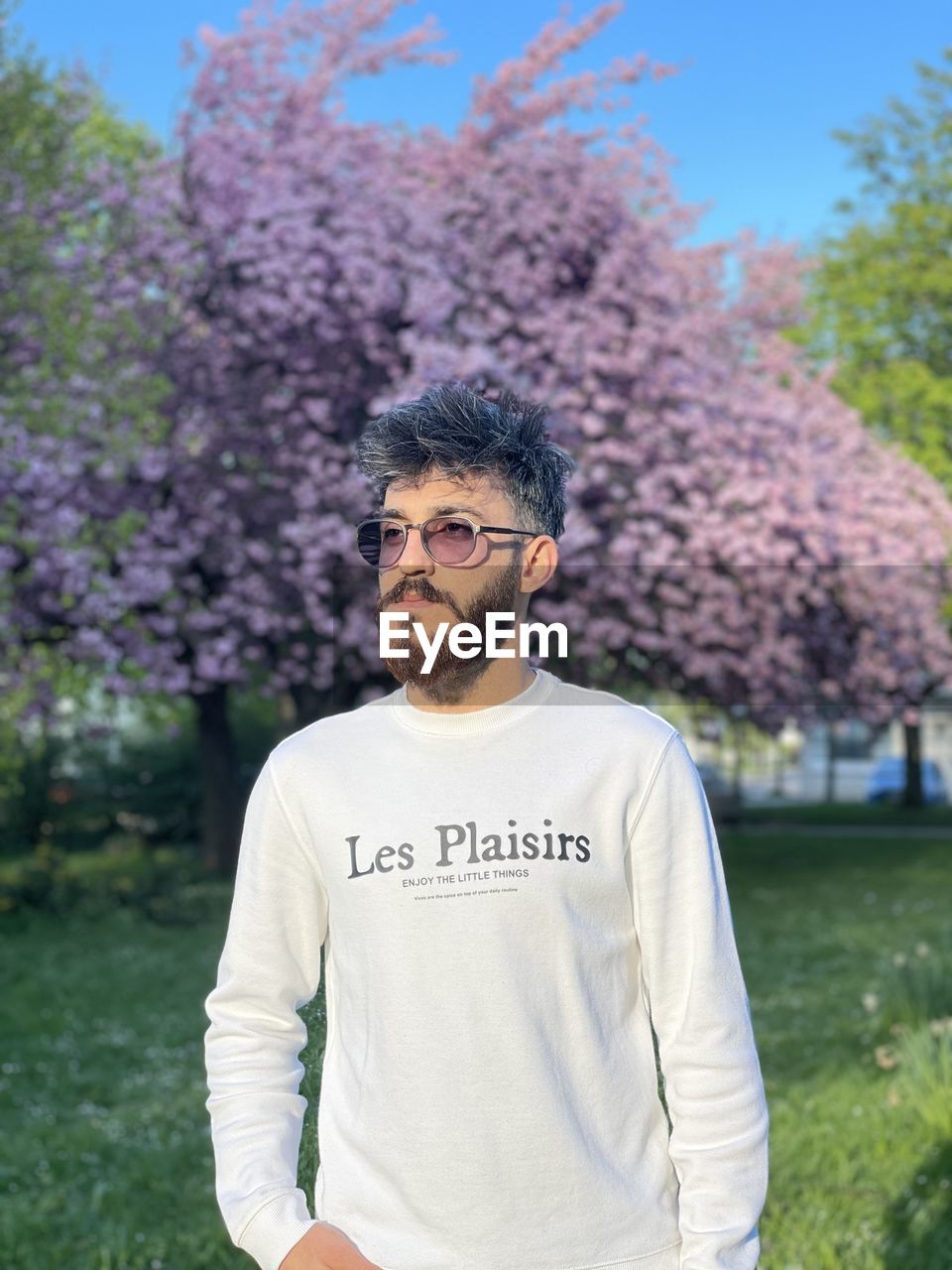 portrait of young man standing against trees