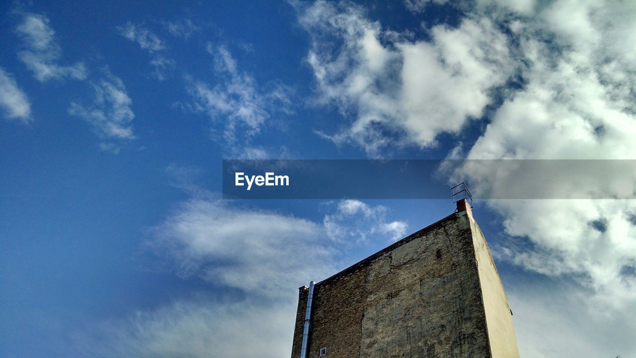 Low angle view building against cloudy sky