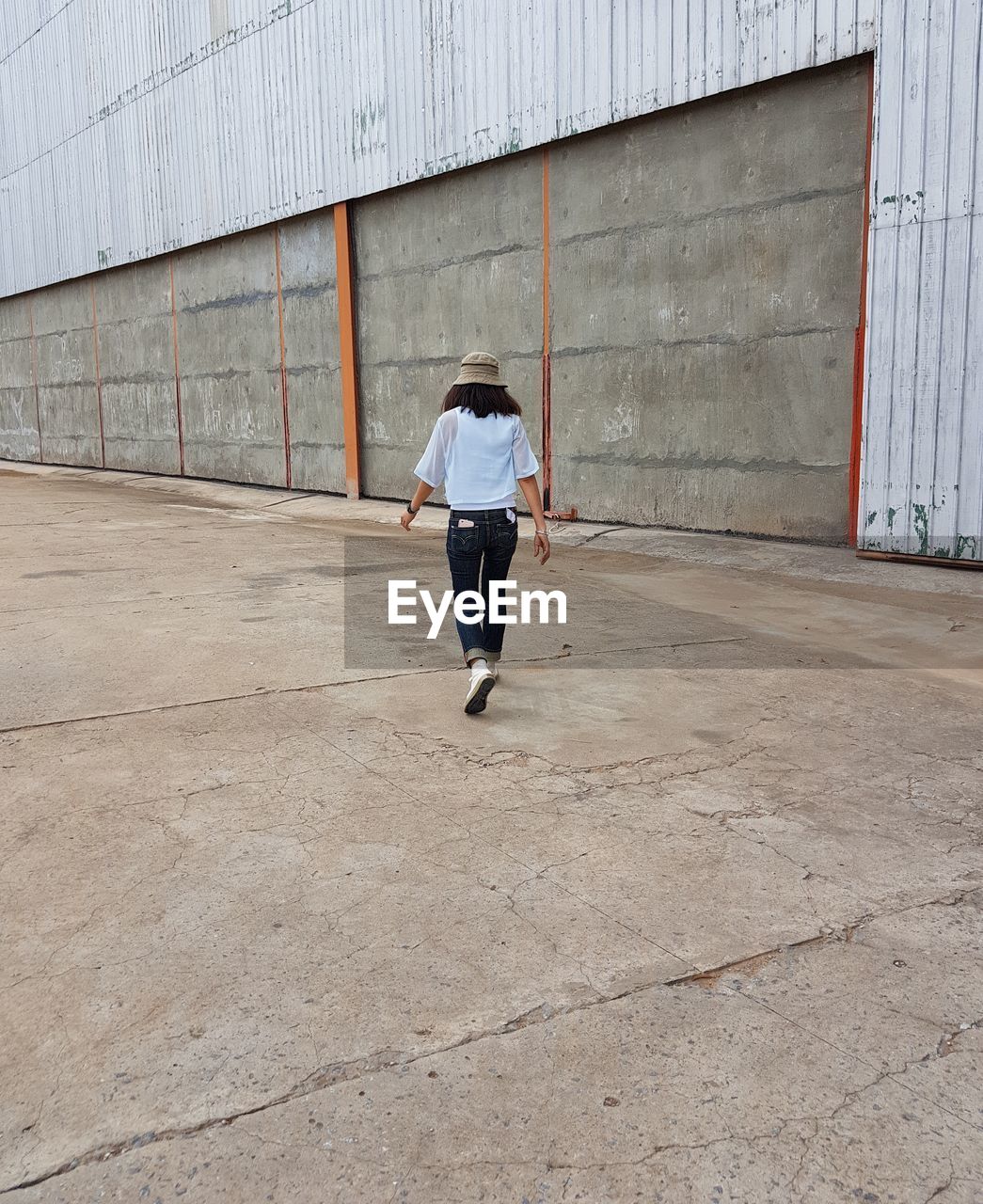 Rear view of woman walking against building