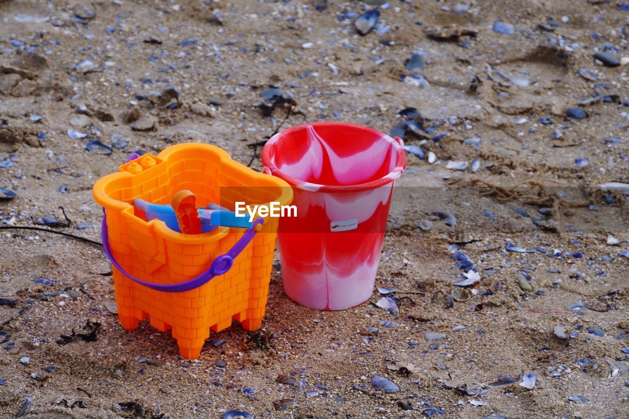 High angle view of buckets on sand at beach