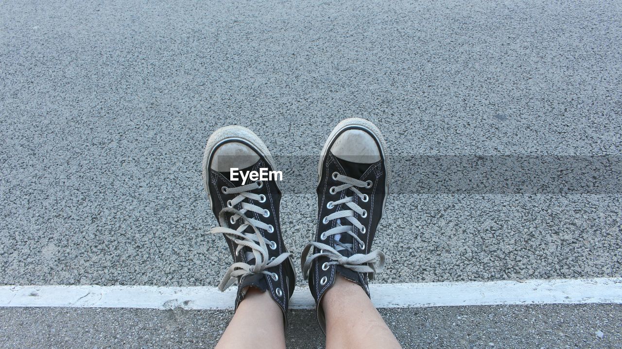 Low section of woman standing on road