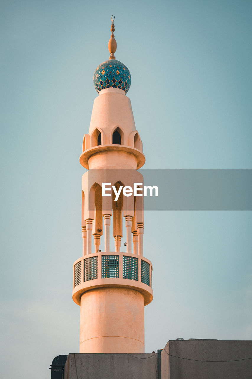 Low angle view of masjid  tower against sky