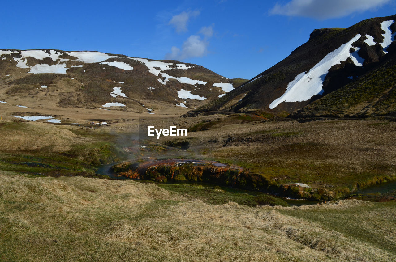 Stunning landscape with steam rising from a hot spring stream in iceland.