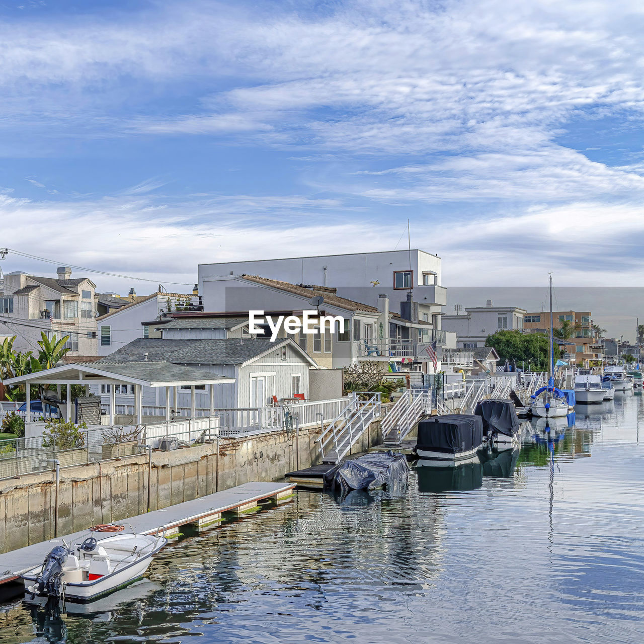 BOATS IN RIVER AGAINST BUILDINGS IN CITY