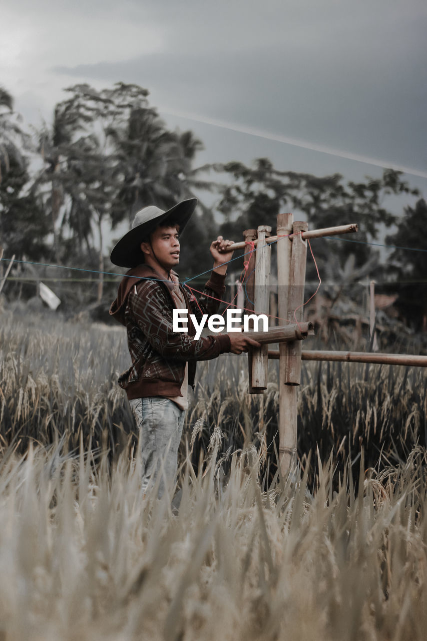 Man wearing hat standing at farm