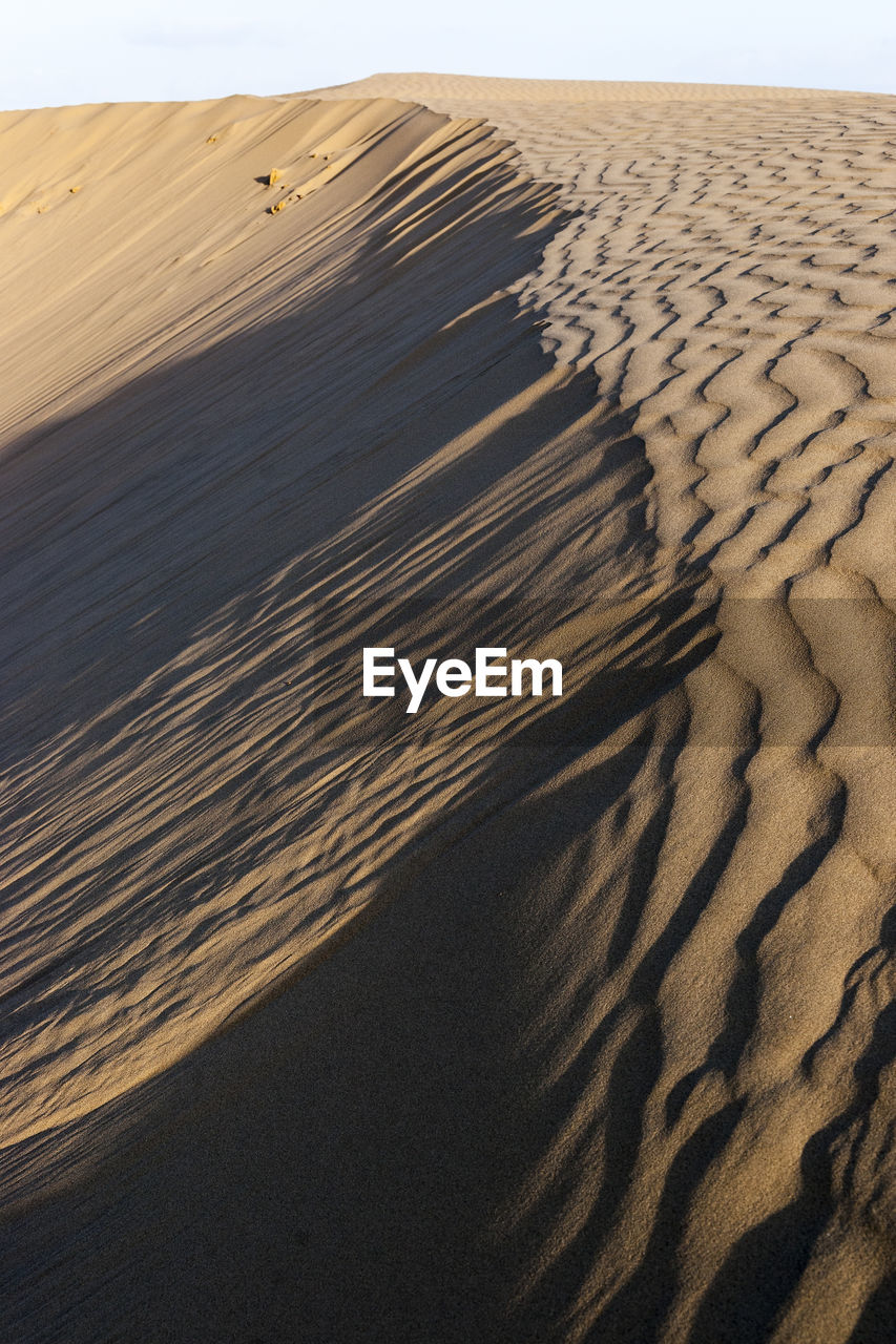 SAND DUNES IN DESERT AGAINST SKY