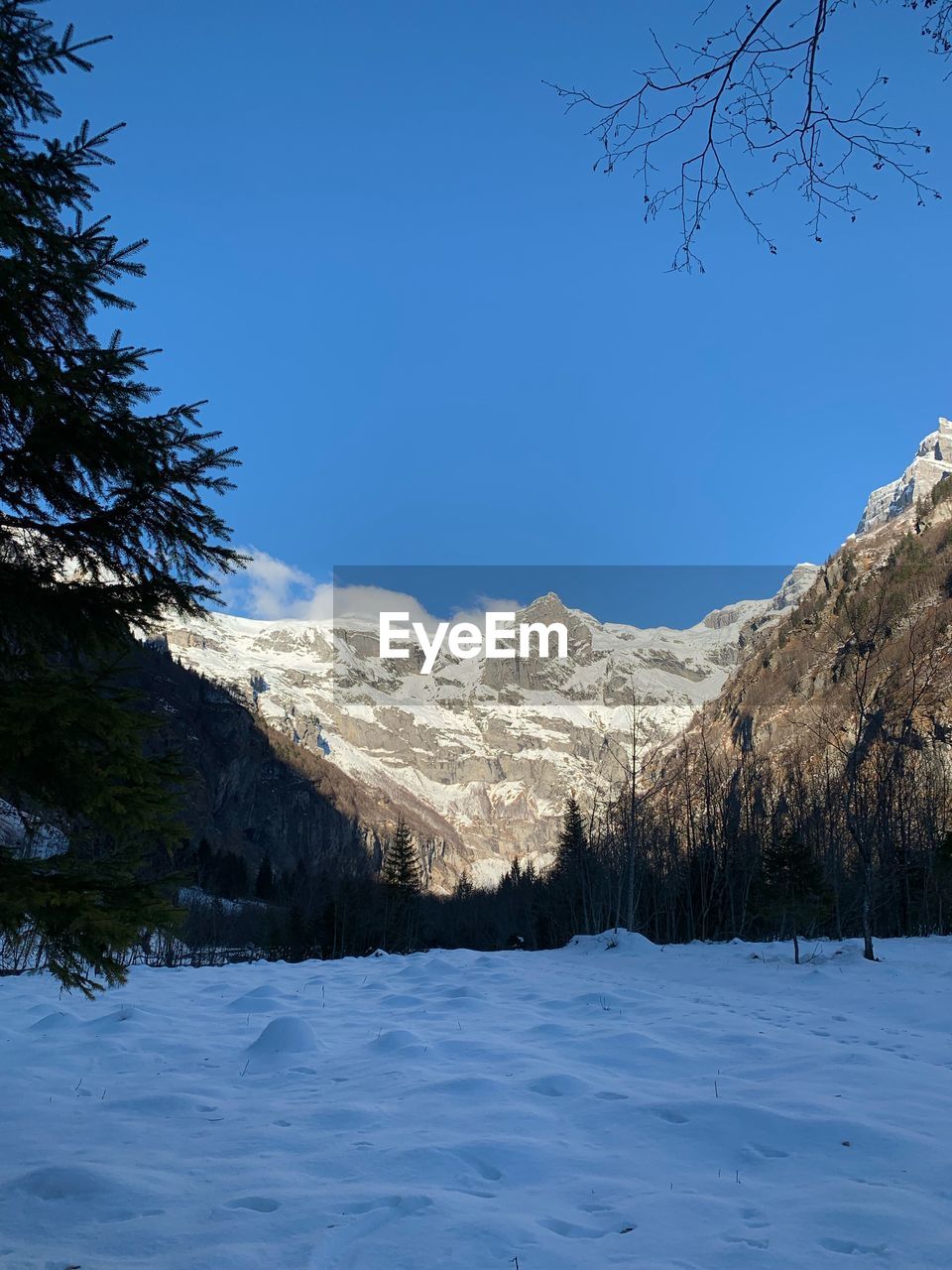 Scenic view of snowcapped mountains against clear blue sky