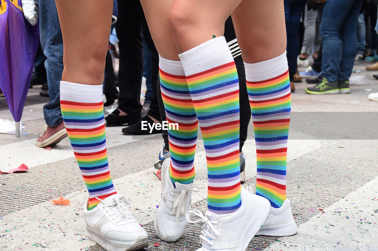 Low section of people wearing colorful socks while standing on street