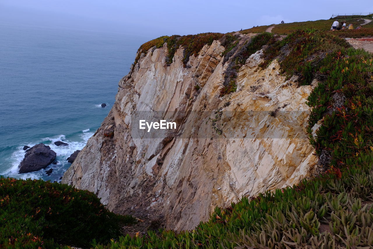 Rock formations by sea against sky