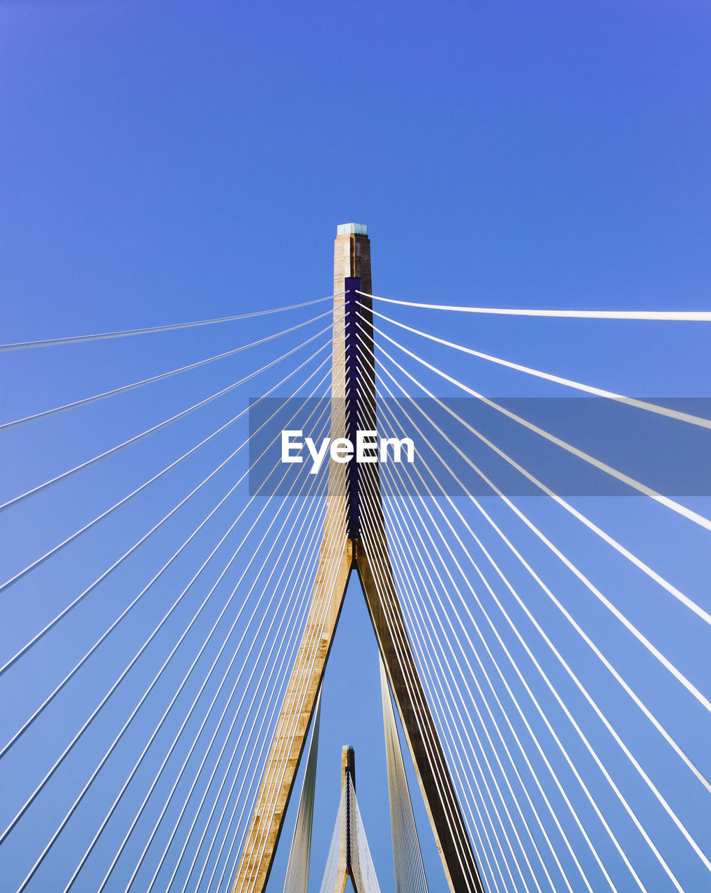 Low angle view of cable-stayed bridge against clear blue sky