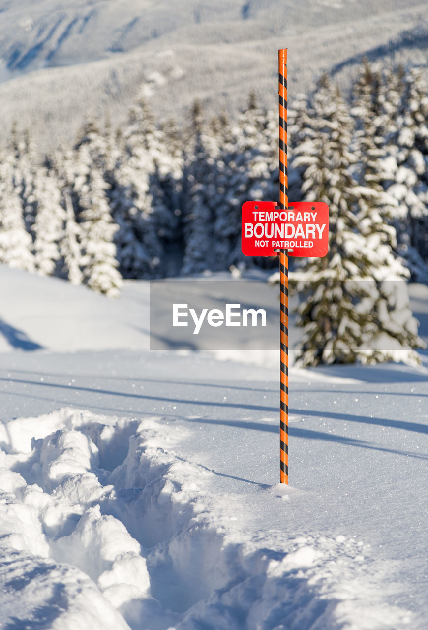 INFORMATION SIGN ON SNOW COVERED FIELD