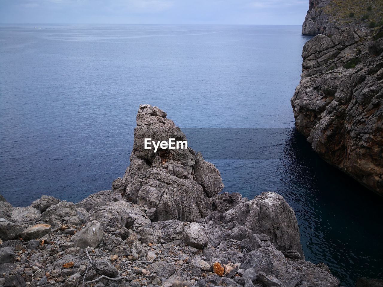 Rock formation in sea against sky