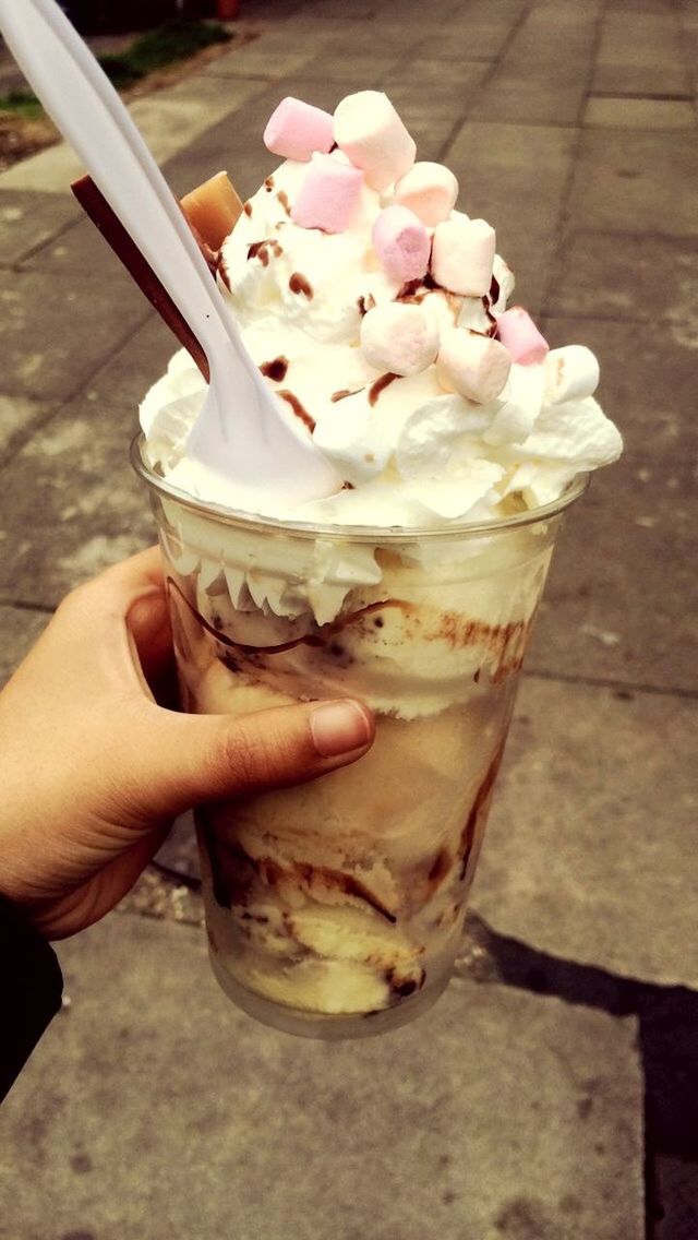 Cropped image of hand holding ice cream outdoors