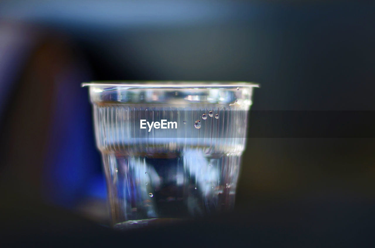 Close-up of water drop of disposable glass