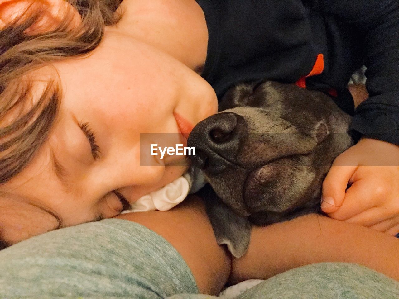 Close-up of boy sleeping with dog on bed at home