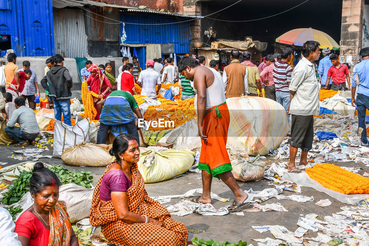 GROUP OF PEOPLE AT MARKET STALL