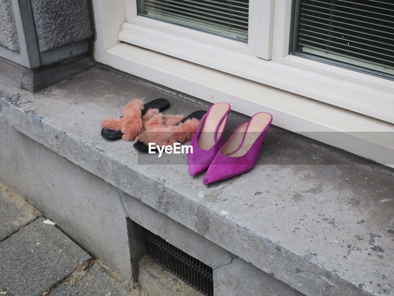 Two pair of ladies shoes left on the windowsill