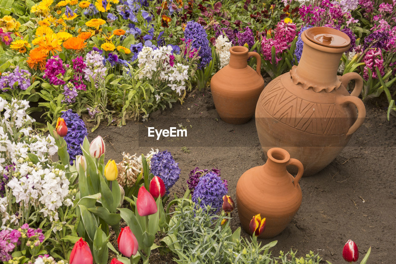 Water container earthenware jugs inside flower bed in outdoor