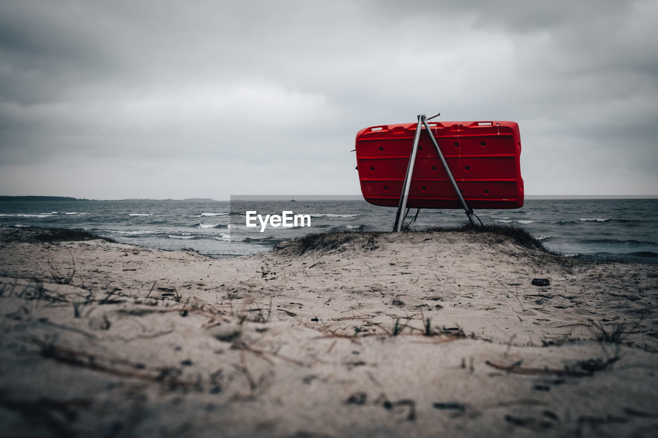beach, land, ocean, sky, sea, water, cloud, red, coast, wave, sand, nature, shore, lifeguard, horizon, horizon over water, scenics - nature, white, beauty in nature, tranquility, overcast, no people, absence, black and white, wind wave, outdoors, tranquil scene, monochrome, storm, day, accidents and disasters, body of water, holiday