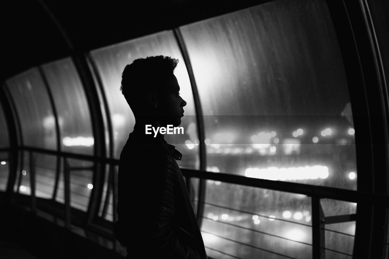 Silhouette man standing on bridge at night