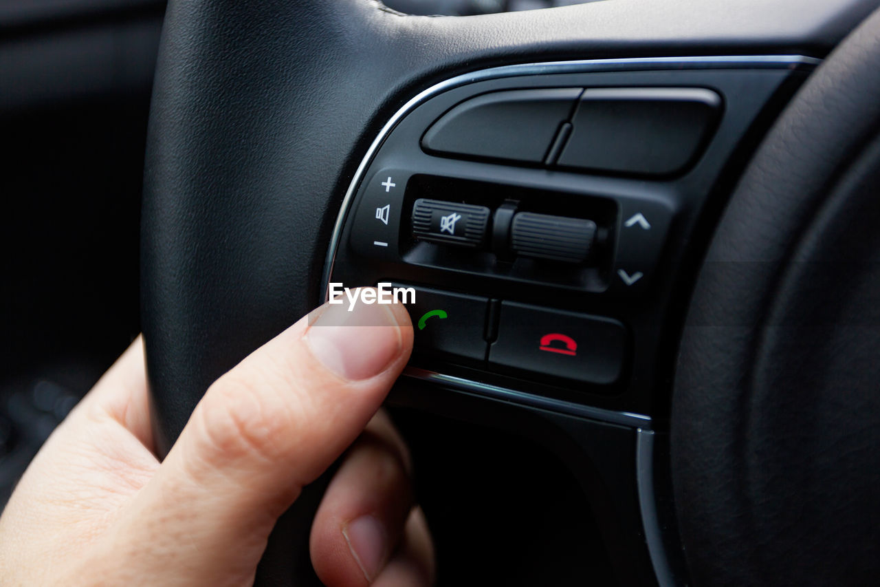 Cropped hand of man driving car