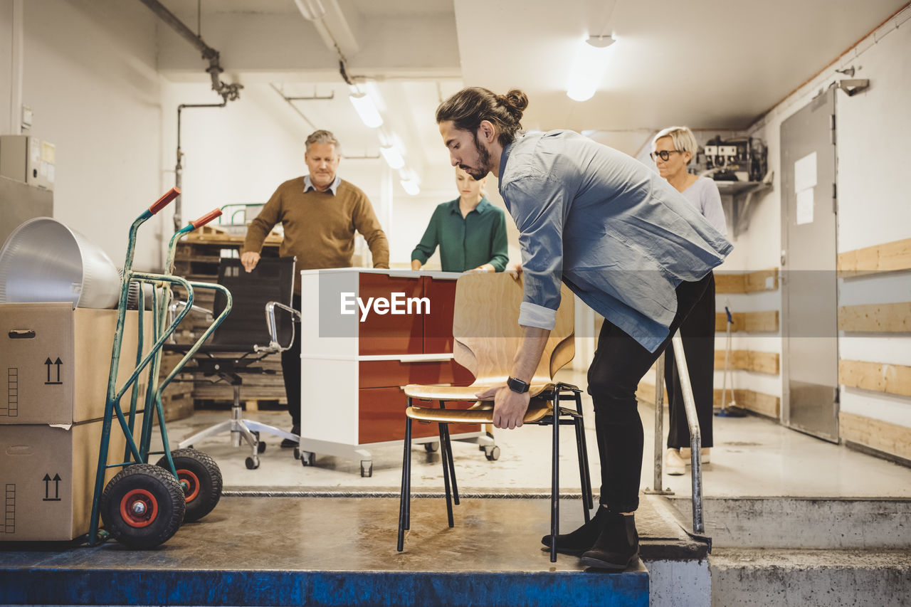 Multi-ethnic business people with equipment moving into new office