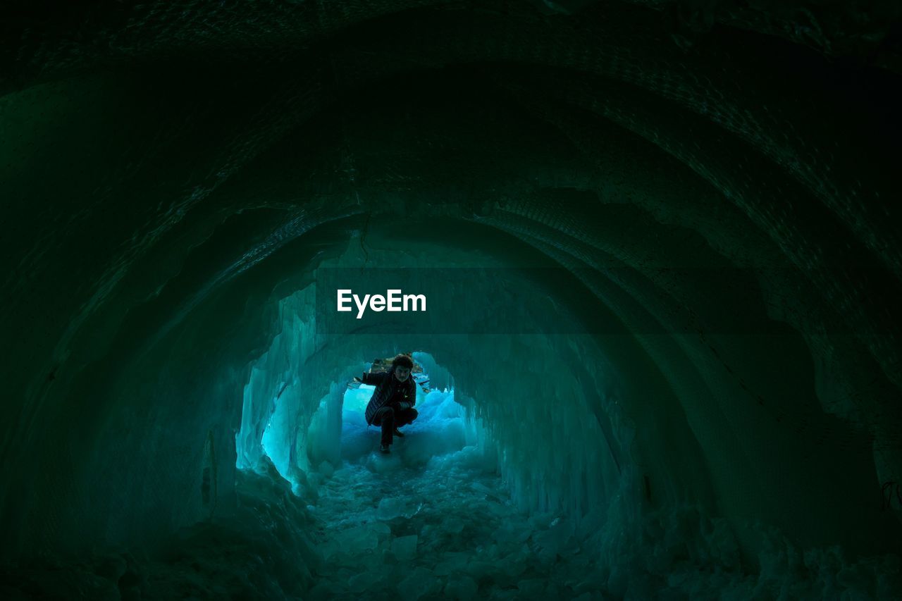 Man in frozen cave during winter