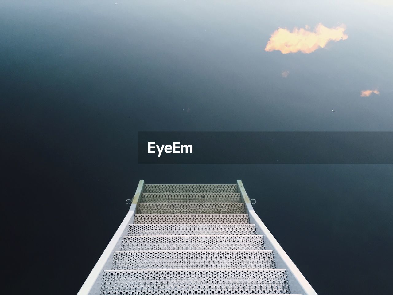 High angle view of ladder leading towards calm lake