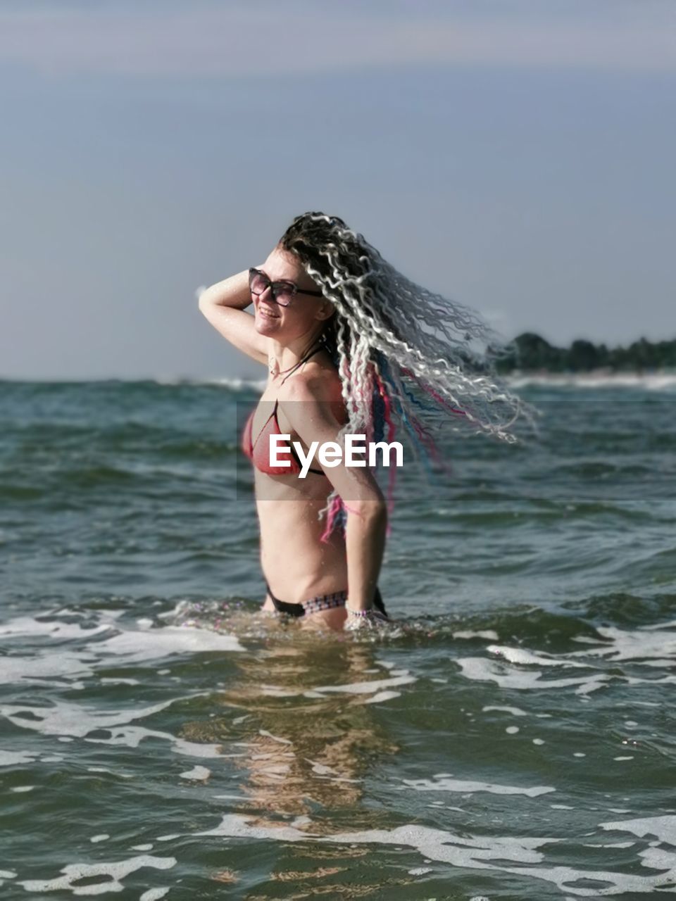 Young woman in bikini standing in sea