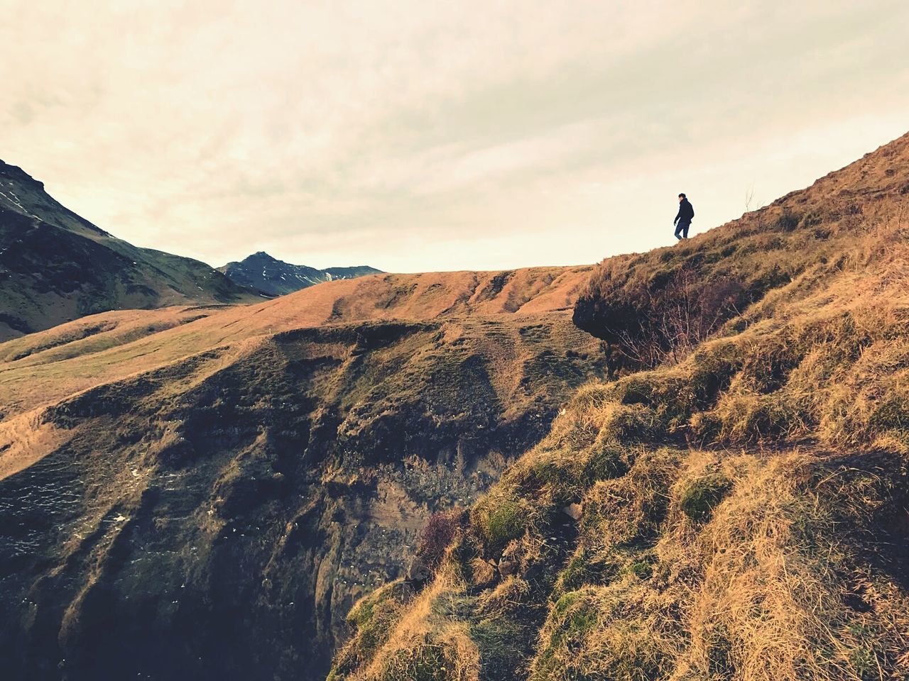 Low angle view of man hiking on mountain against sky