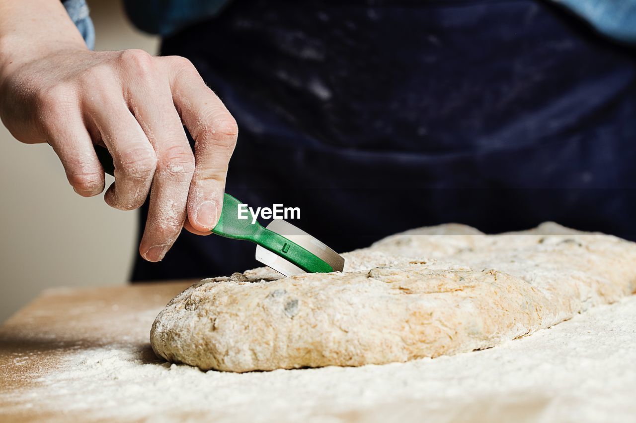 Midsection of person preparing food in kitchen