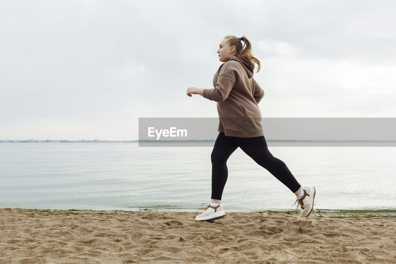 Young woman jogging on beach