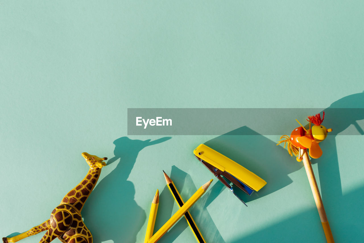 High angle view of toys and pencils on blue background