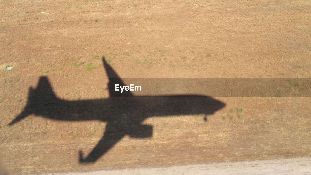 HIGH ANGLE VIEW OF AIRPLANE FLYING OVER A WALL