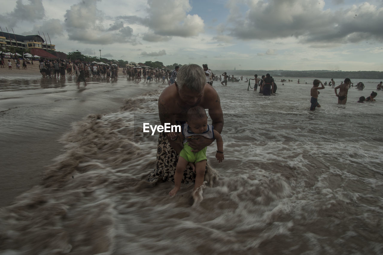 MAN ON BEACH AGAINST SKY