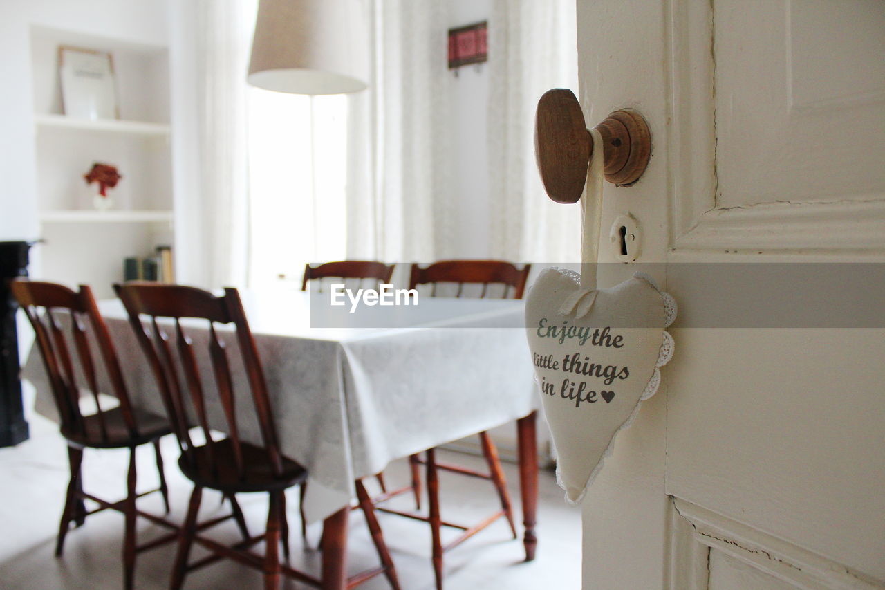 Close-up of text on heart shaped decoration hanging on door