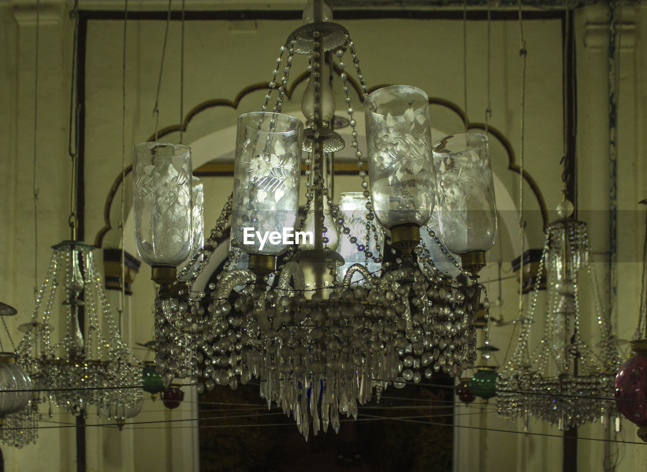 CLOSE-UP OF ILLUMINATED LIGHT BULBS HANGING ON STORE