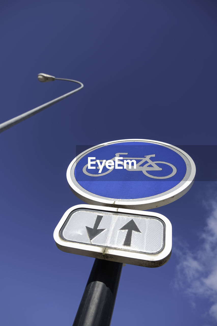 blue, sign, sky, communication, road sign, symbol, guidance, road, arrow symbol, no people, low angle view, nature, directional sign, traffic sign, outdoors