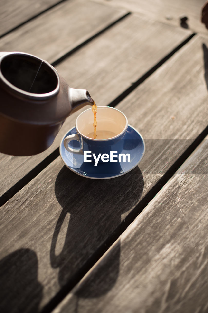 High angle view of tea being served in cup on wooden table