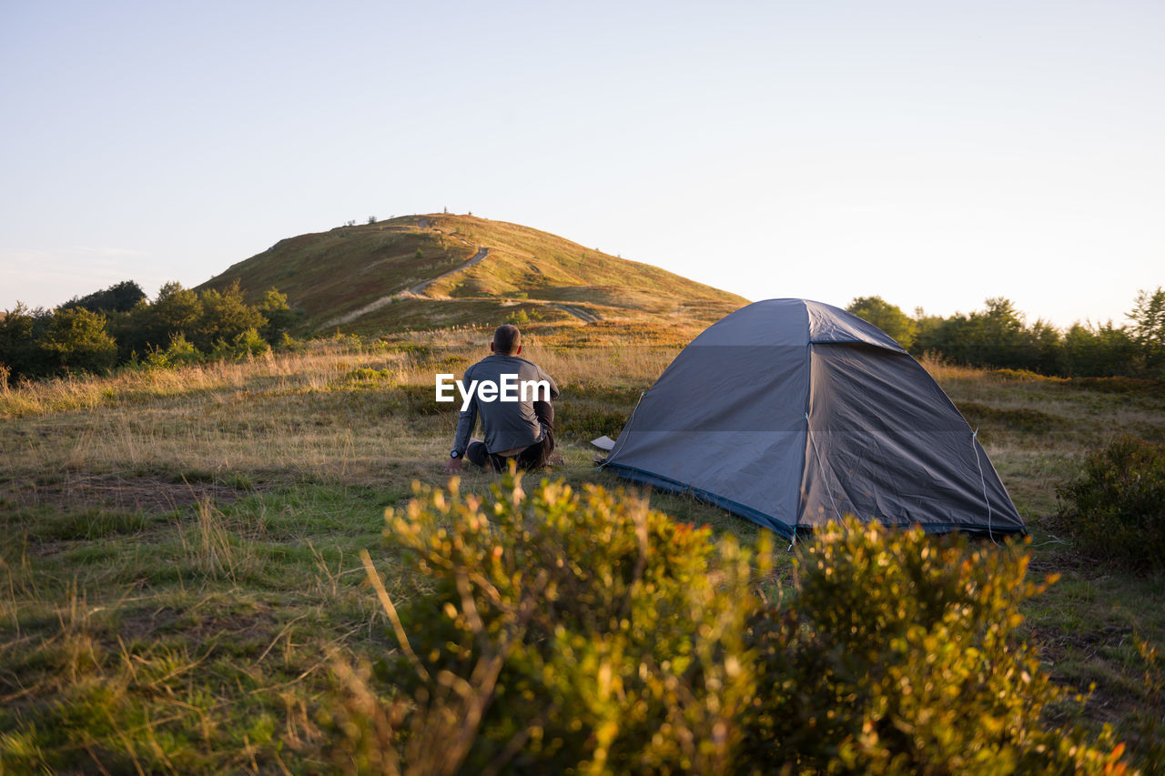 One man near tent at mornin